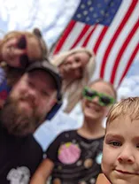 Allen and family smiling under American flag