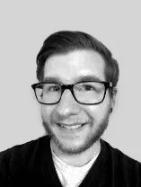 headshot of smiling man wearing glasses