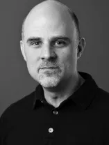 black and white headshot of smiling man