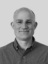 headshot of smiling man wearing glasses