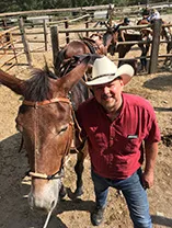 Lon in cowboy hat with horses
