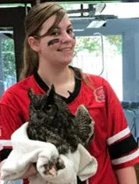 a color photo of Shannon holding an owl in a vet clinic
