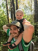 Thomas hiking with toddler son on his shoulders
